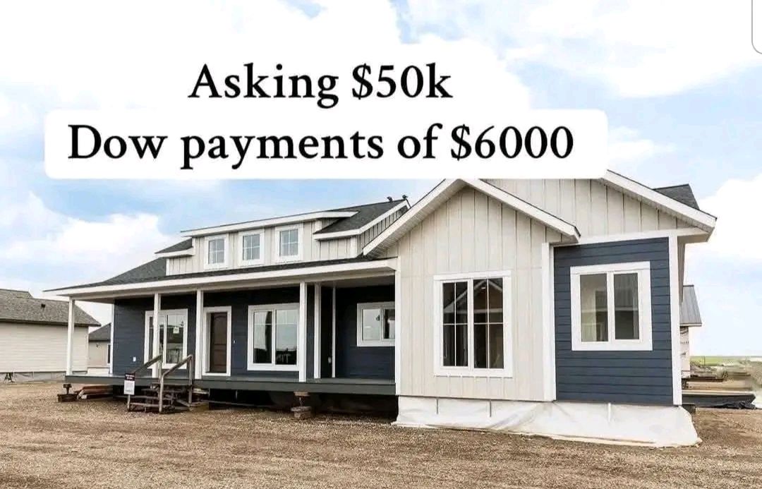 Single-story blue and white house with porch on dirt lot. Text above reads "Asking $50k, Dow payments of $6000." Bright sky overhead.