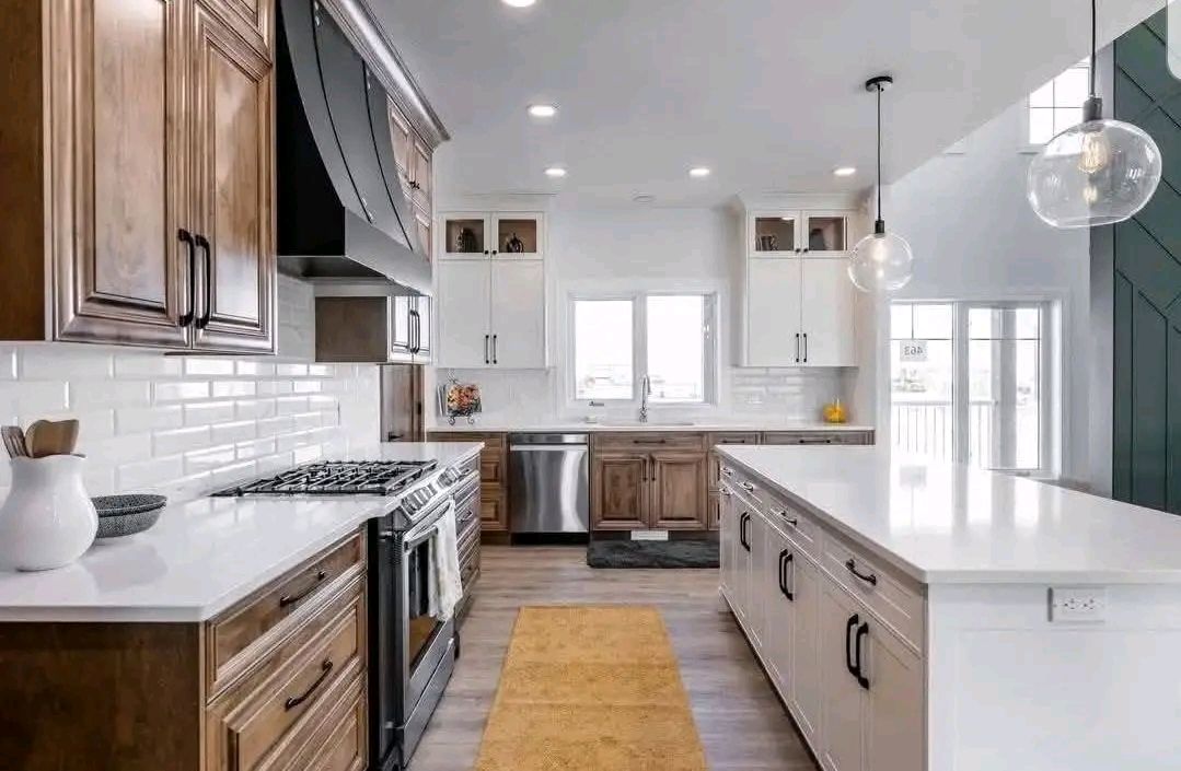 Modern kitchen with wood and white cabinets, a long island, stainless steel appliances, and pendant lights. Bright, airy, with a warm ambiance.