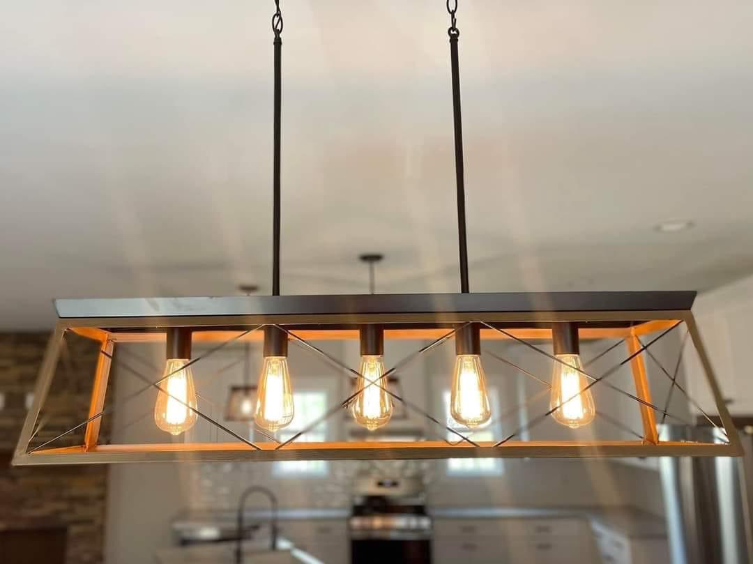 Industrial-style kitchen light fixture with five exposed Edison bulbs inside a rectangular metal frame, creating a warm, modern ambiance.