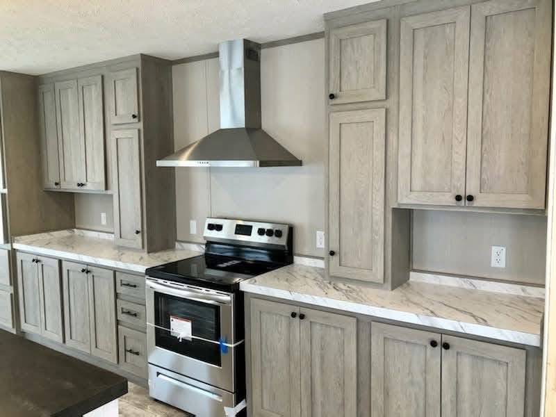 Modern kitchen with light wood cabinets, marble countertops, stainless steel stove, and range hood. Elegant, clean, and organized atmosphere.