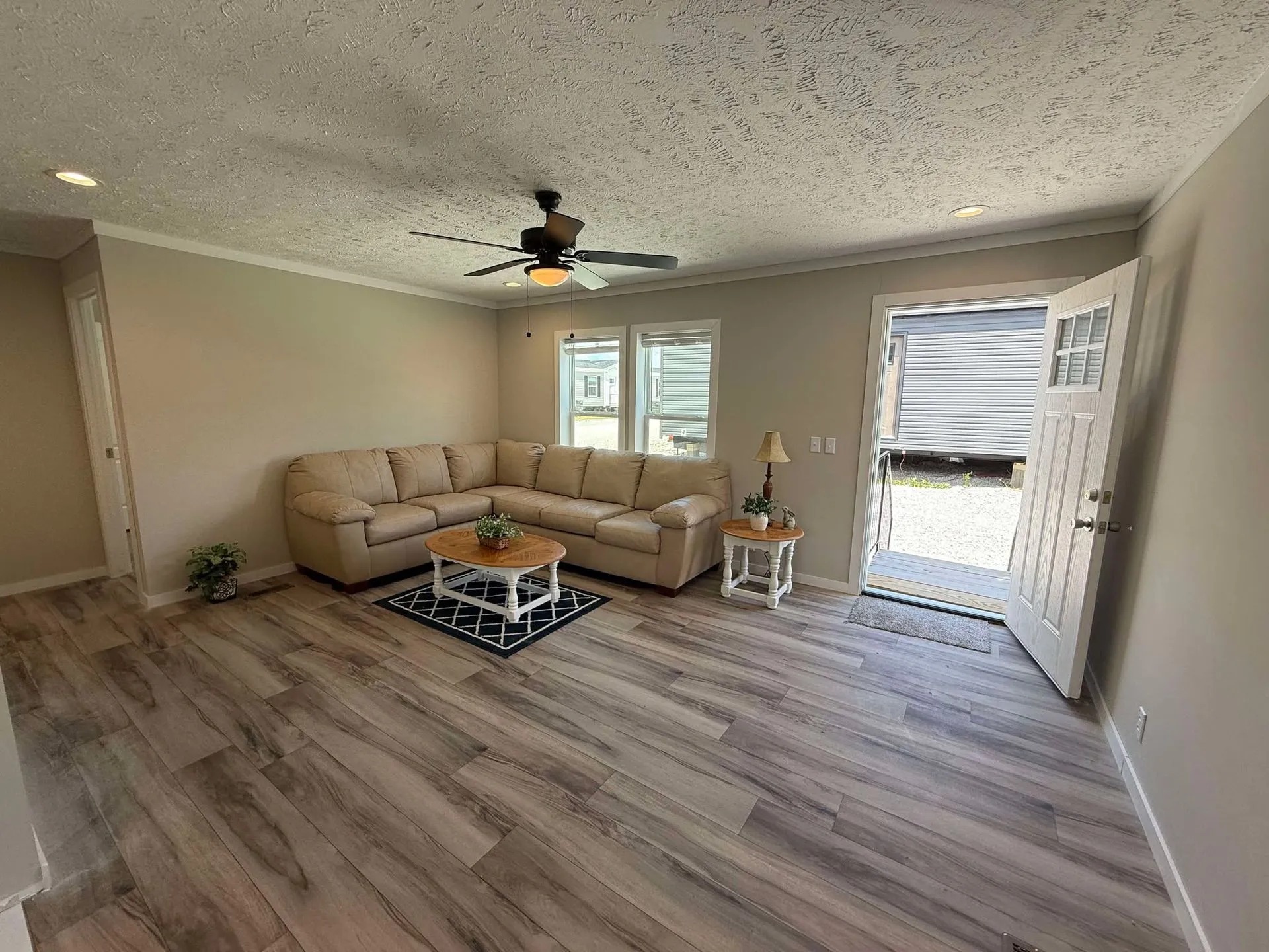 Modern kitchen with new stainless steel fridge, overhanging cabinet, and built-in microwave. Bright, clean design with white cabinetry.