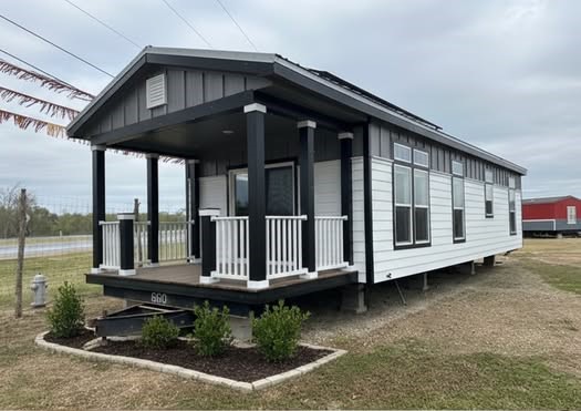 This extensive collection of premium tiny homes, park models, and manufactured homes highlights the "Boujee XL" aesthetic, blending modern farmhouse charm with rustic luxury. Exterior architectural styles feature crisp white and cream board-and-batten siding with white or charcoal metal roofs, black-pillared gabled porches, and elegant white or black metal railings, as well as a rustic log-cabin style model featuring natural wood siding and a forest green metal roof. Interiors emphasize an upscale lifestyle with vaulted ceilings, exposed wood beams, and white shiplap walls. Gourmet kitchen designs range from rustic wood cabinetry with stone-look backsplashes and white appliances to sophisticated modern spaces with white or grey cabinetry, marble-look or distressed wood countertops, stainless steel farmhouse sinks, and elegant pendant lighting. Functional luxury is integrated throughout open-concept living areas, featuring wide-plank wood-look flooring, industrial-style black ceiling fans, and large transom windows that provide abundant natural light. Many models also include integrated lofted sleeping quarters accessed by wooden ladders or stairs, built-in breakfast nooks, and modern bathrooms with walk-in tile showers.