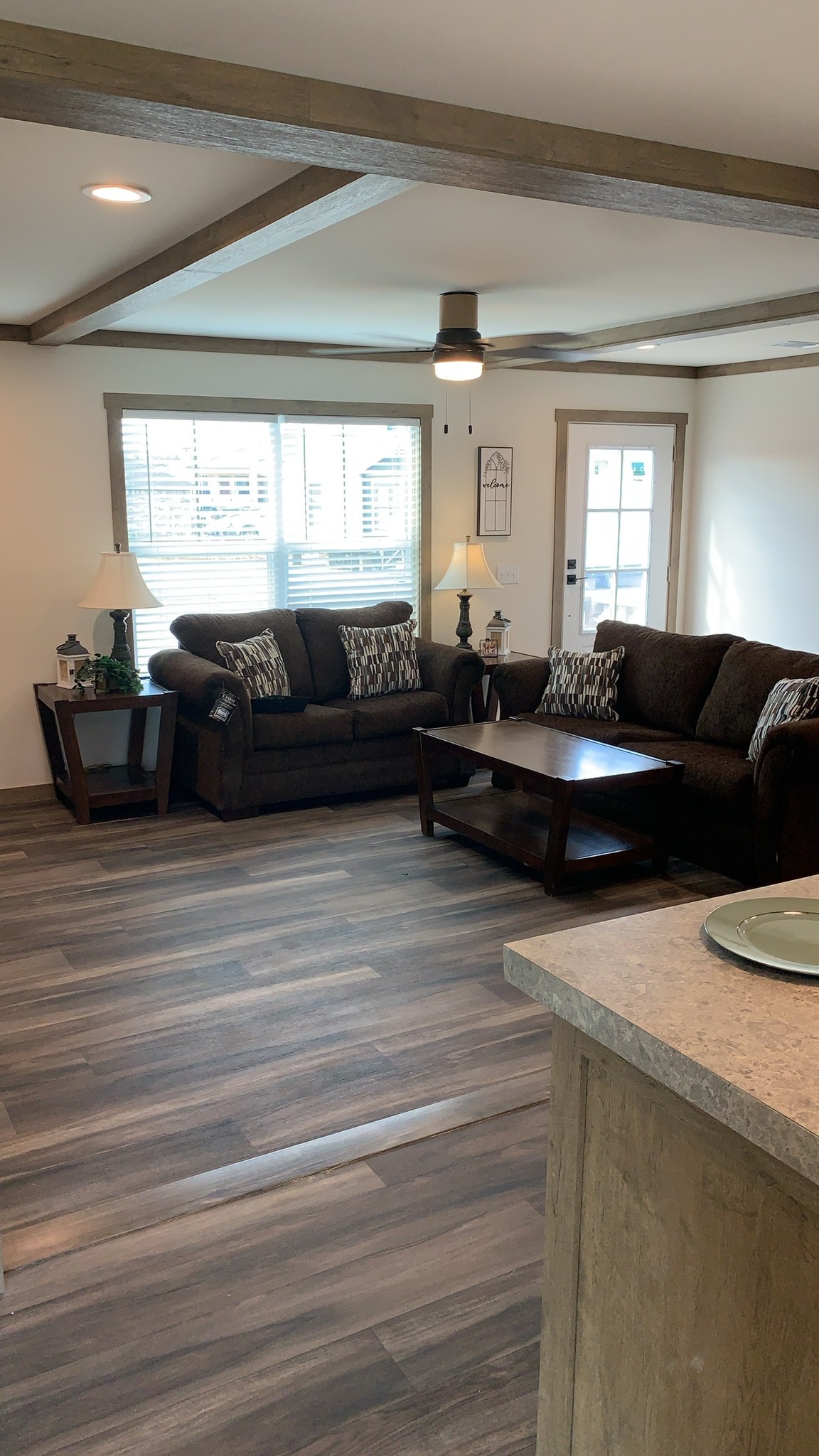 Comprehensive luxury modular home showcase featuring the 819 SQ FT APH 1662C floor plan, modern white kitchens with quartz waterfall islands, hidden arched pantries, industrial corrugated metal islands, stone fireplaces, and rustic-modern living spaces with vaulted ceilings and sliding barn doors.