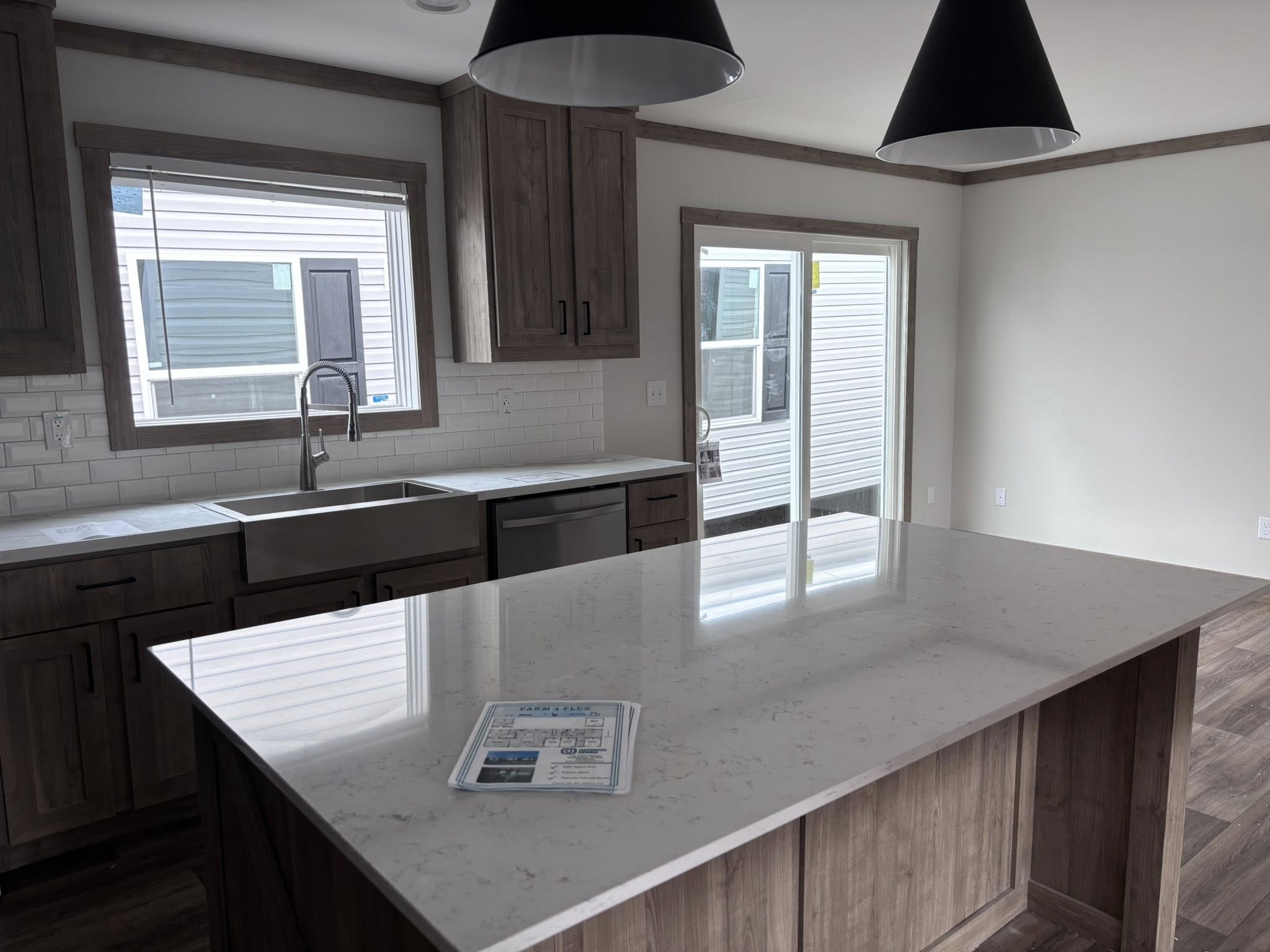 ALT TEXT
This extensive image gallery features the "Boujee XL" series of luxury tiny homes, park models, and manufactured homes, emphasizing a modern farmhouse aesthetic combined with high-end functional design. The exteriors highlight a variety of sophisticated color palettes, including crisp white and cream board-and-batten siding accented by charcoal gables, spacious gabled front porches with black or white pillars, and durable metal roofs in white or dark grey. The interior living areas feature open-concept layouts with vaulted ceilings, natural wood-plank ceilings with recessed lighting, or painted beams, complemented by wide-plank wood-look flooring and crisp shiplap or neutral-toned walls. Gourmet kitchens are designed for high functionality, featuring cabinetry in finishes ranging from light natural oak to elegant black or off-white, paired with marble-look or distressed wood countertops, stainless steel farmhouse sinks, and unique vibrant teal appliances in select models. Functional luxury is further integrated through built-in booth seating, industrial-style ceiling fans, transom windows that flood spaces with natural light, and carpeted bedrooms designed for comfort.