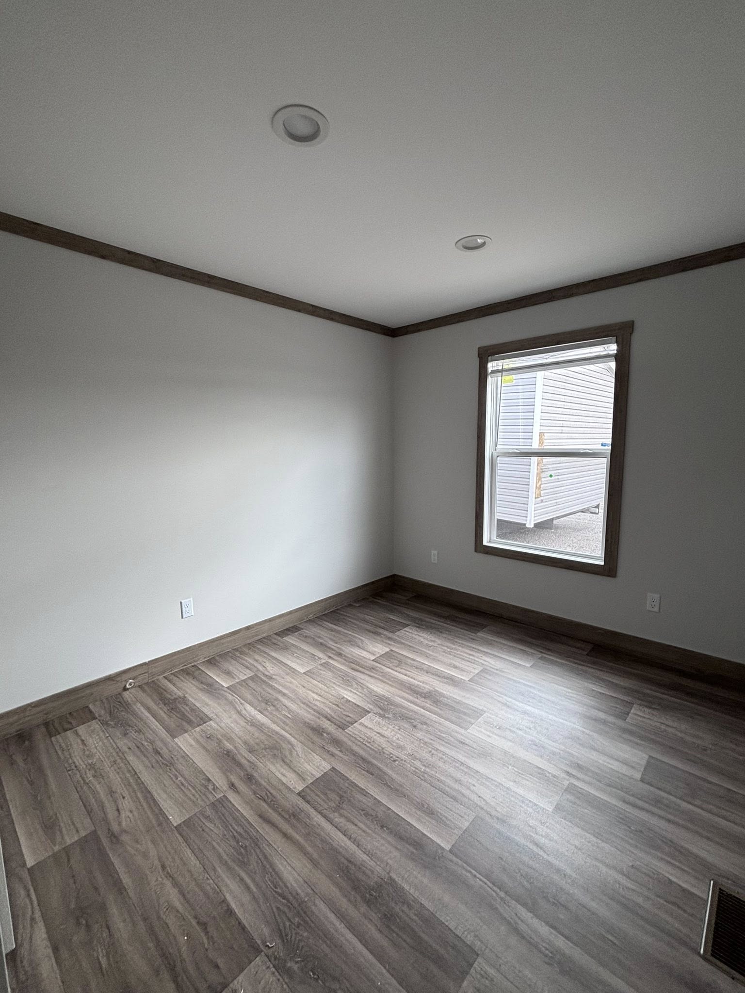 This extensive image gallery showcases the "Boujee XL" series of luxury tiny homes and manufactured residences, featuring a refined modern farmhouse aesthetic through high-end exterior and interior finishes. Exterior designs highlight high-contrast palettes, such as white or cream board-and-batten siding paired with dark charcoal gables, gabled front porches with black or white support pillars, and durable metal roofs. The interior living areas emphasize open-concept luxury with vaulted ceilings—some featuring natural wood planks, exposed beams, or industrial ceiling fans—complemented by wide-plank wood-look flooring and crisp shiplap or neutral walls. Gourmet kitchens are equipped with premium features, including cabinetry in natural oak, white, or black finishes, marble-patterned or wood-block countertops, stainless steel farmhouse sinks, and large center islands with modern pendant lighting. Additional functional luxury elements include integrated loft spaces, transom windows for maximum natural light, built-in breakfast booths, and contemporary bathrooms with black hardware and white vanities.