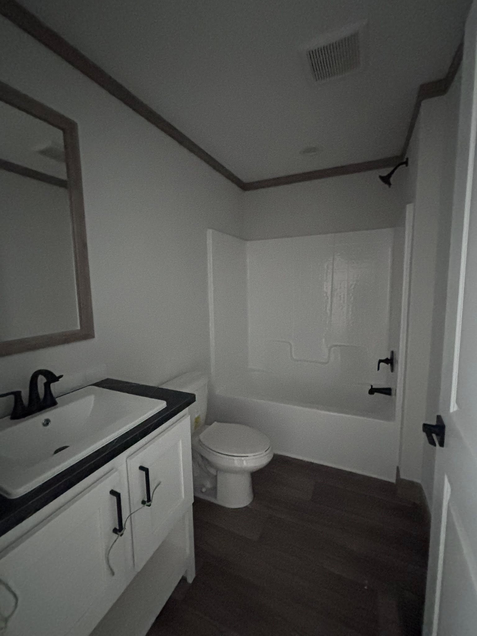 This detailed collection highlights the "Boujee XL" series of luxury tiny homes and manufactured residences, showcasing a refined modern farmhouse aesthetic with high-end finishes. Exterior designs feature high-contrast palettes, such as white or cream board-and-batten siding paired with dark charcoal gables, spacious gabled front porches with black or white support pillars, and durable metal roofs. The interior living areas emphasize open-concept luxury with vaulted ceilings—some featuring natural wood planks or exposed beams—complemented by wide-plank wood-look flooring and crisp shiplap walls. Gourmet kitchens are equipped with premium features, including cabinetry in natural oak, white, or black finishes, marble-patterned or wood-block countertops, stainless steel farmhouse sinks, and large center islands with modern pendant lighting. Additional functional luxury elements include integrated loft spaces, industrial-style ceiling fans, transom windows for maximum natural light, built-in breakfast booths, and contemporary bathrooms with black hardware and walk-in showers or tubs.