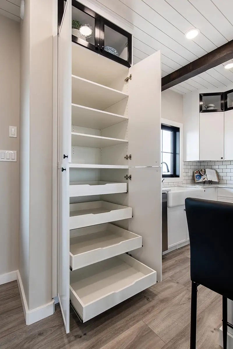 Modern modular farmhouse showcase featuring the APH 1662C 819 SQ FT floor plan, white vertical siding exteriors with front porches, and luxury interiors with granite waterfall islands, vaulted shiplap ceilings, stacked stone fireplaces, rustic sliding barn doors, and smart pantry storage solutions.