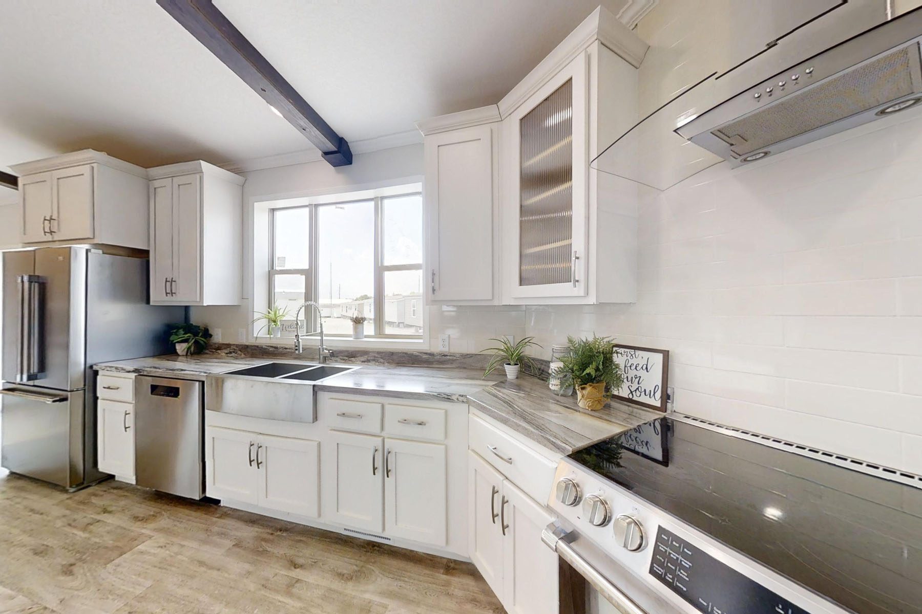 
Gemini said
Modern transitional kitchen interior featuring white shaker cabinets, premium grey marble-style countertops, and a large stainless steel farmhouse sink under a bright window, complemented by a spacious kitchen island with rustic wood barstools, dark wood ceiling beams, and high-end stainless steel appliances on light oak hardwood flooring for a luxury home renovation and open-concept design inspiration.