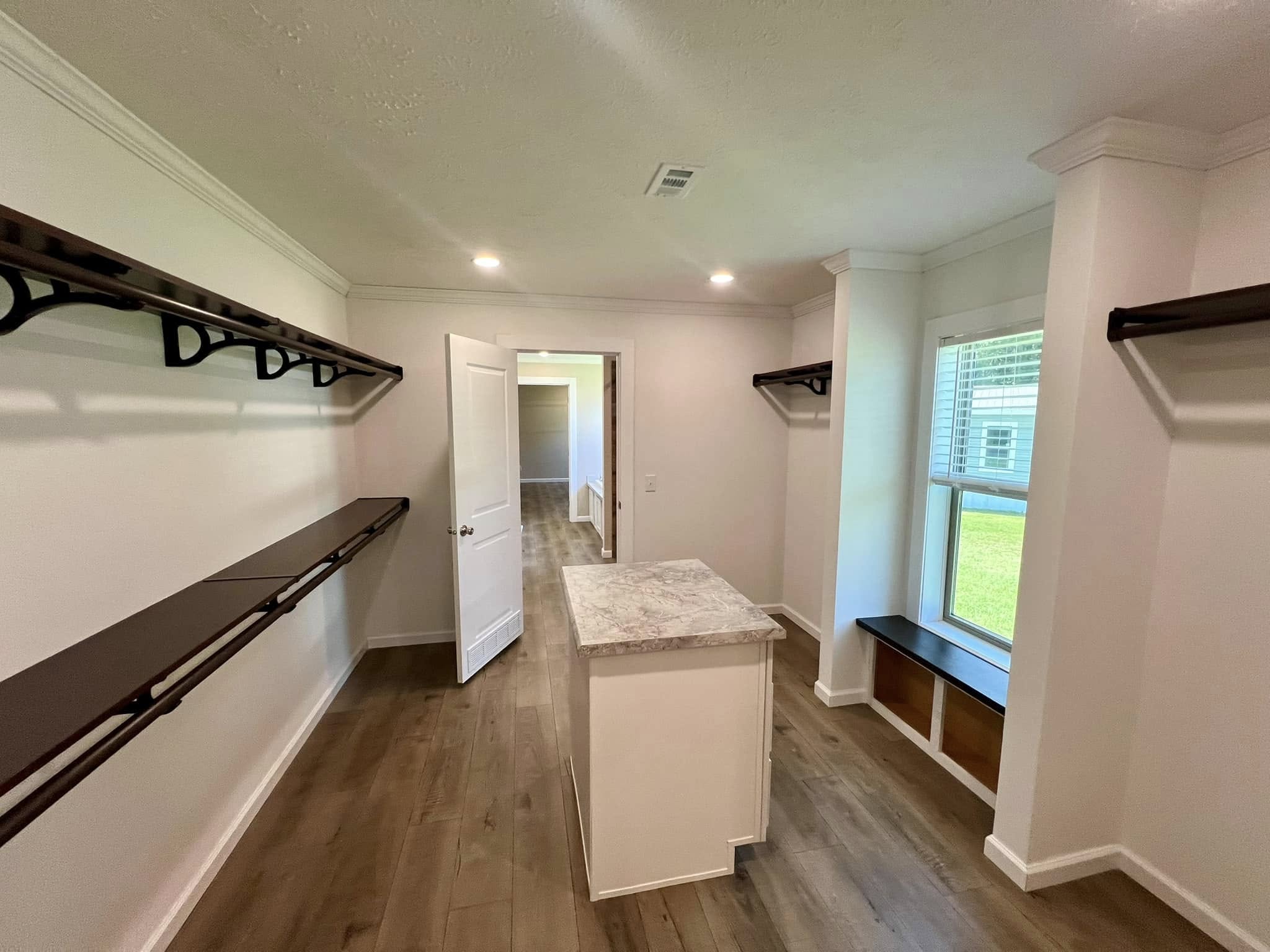 SEO-optimized alt text for a luxury manufactured home interior, featuring a spacious gourmet kitchen with white shaker cabinetry, a large kitchen island with a reclaimed wood-style countertop, and a rustic red brick backsplash; the open-concept floor plan showcases premium finishes like stainless steel appliances, modern pendant lighting, and durable wood-look flooring that flows into a bright dining area and living room, perfectly capturing the essence of high-end mobile living, contemporary farmhouse decor, and innovative modular home design for maximum search engine ranking and visibility.

Would you like me to focus on a different room, like the master walk-in closet or the exterior view, for the next one?