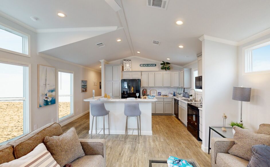 A bright, airy beach house living room and kitchen feature plush beige sofas, modern decor, light wood floors, and a minimalist design, evoking relaxation.