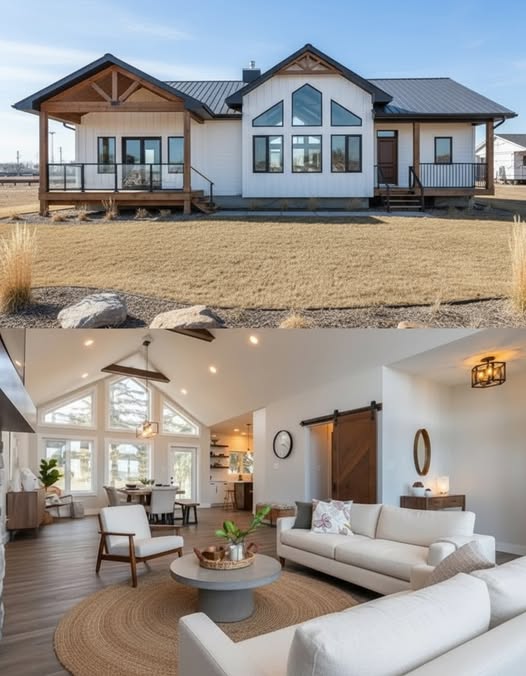 Modern luxury home exterior and interior design showcase featuring a white farmhouse-style modular home with a black metal roof and timber gables, paired with a bright open-concept living room. The interior highlights a vaulted ceiling with large geometric windows, a neutral sectional sofa, mid-century modern accent chairs, and a round jute rug over hardwood floors, creating a seamless blend of contemporary industrial and rustic architectural elements.