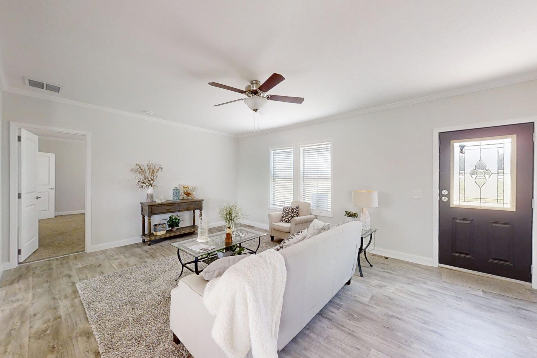 
Gemini said
Modern transitional kitchen interior featuring a double-bowl white porcelain farmhouse sink with a brushed nickel gooseneck faucet, light oak butcher block countertops, and white shaker cabinetry, with a clear view into a bright living room showcasing a striped accent chair and neutral decor for a high-end residential real estate and home renovation inspiration.