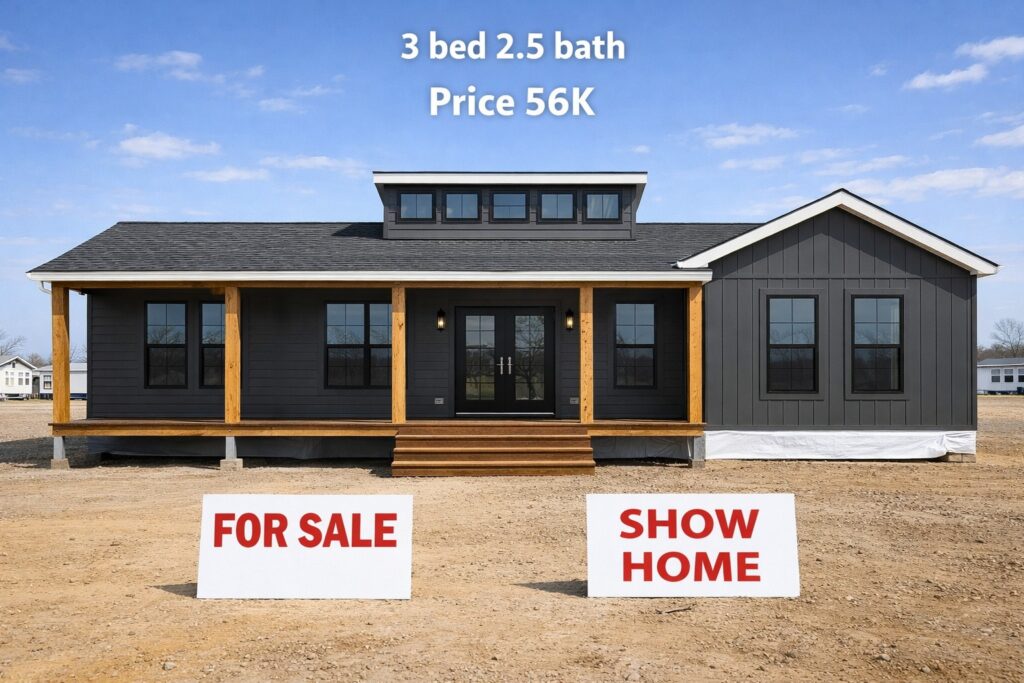 Gray show home with modern architecture, featuring a porch and large windows. Signs in front read "For Sale" and "Show Home." Text above offers "3 bed 2.5 bath, Price 56K."