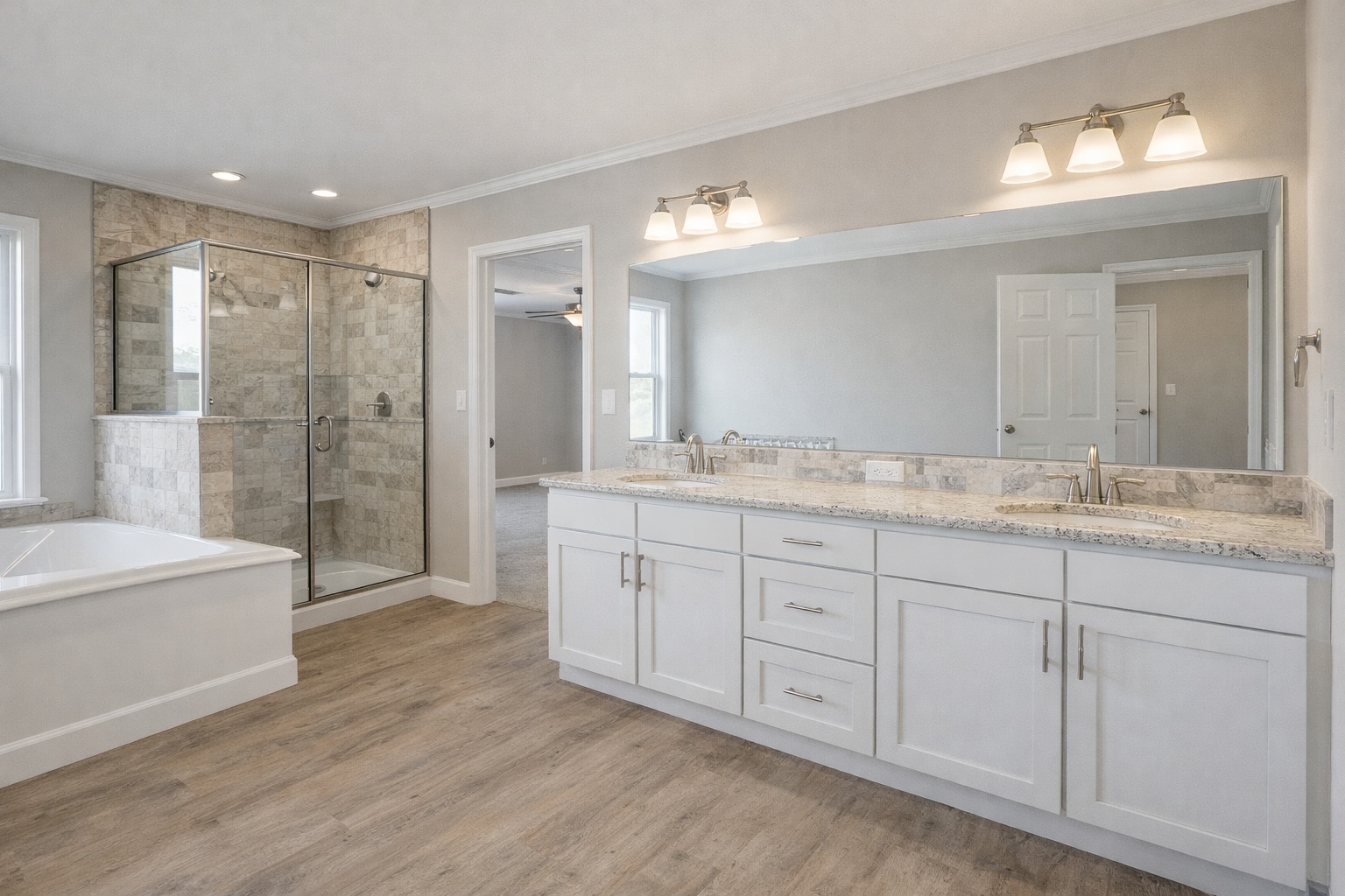 Modern bathroom with light wood flooring, large mirror, dual sinks on a white vanity, glass-enclosed shower, and a bathtub, creating a serene ambiance.