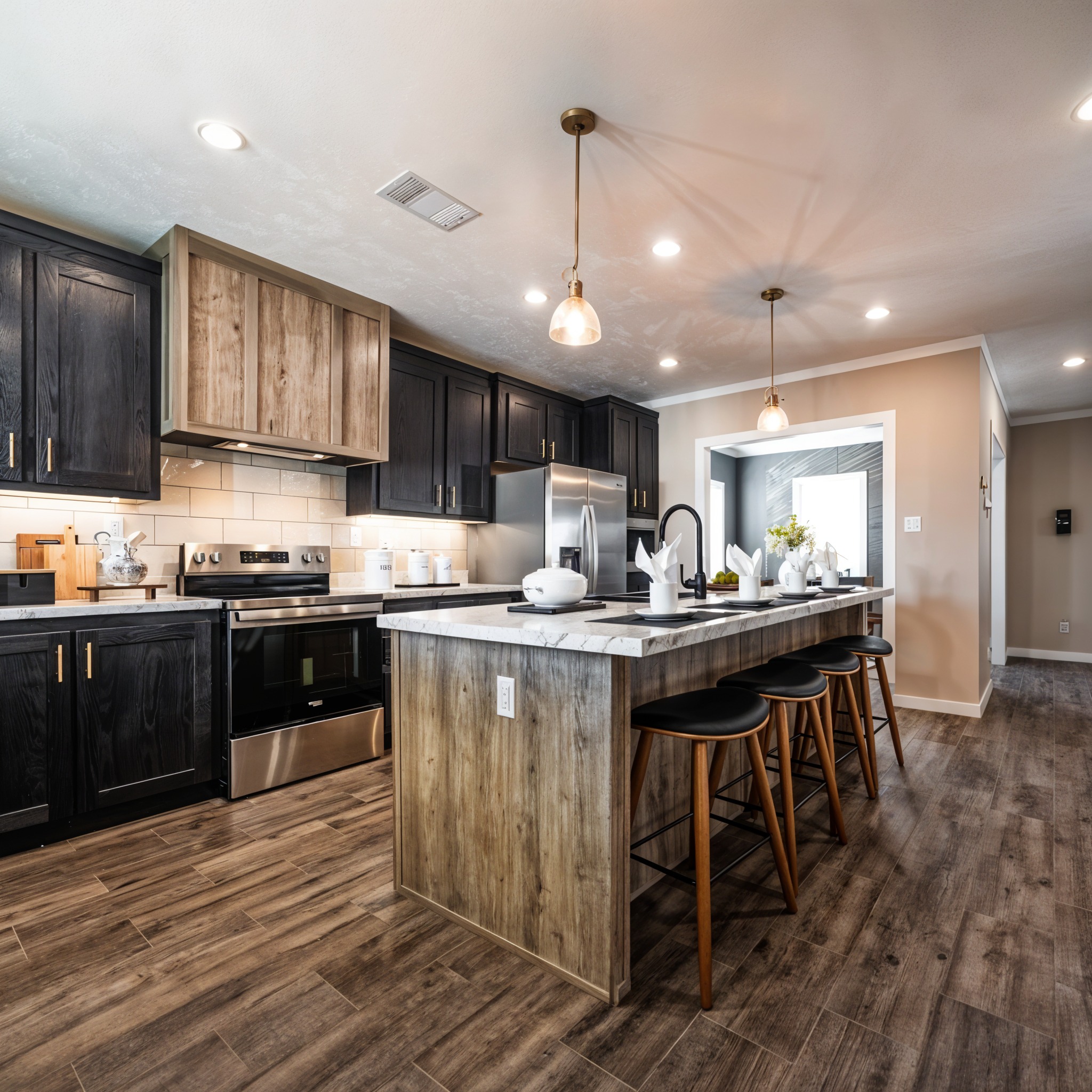 Modern kitchen with wood and dark cabinets, stainless steel appliances, and a marble island. Pendant lights hang over four bar stools, creating a warm ambiance.