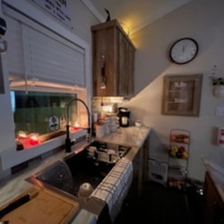 Luxury walk-in shower design for a modern tiny home or manufactured house, featuring large-format light gray wall tiles with a vertical mosaic accent strip, matte black fixtures including a rain shower head and handheld sprayer, built-in corner shelves, and a crisp white shower pan; the high-end bathroom interior showcases a minimalist aesthetic with clean lines and premium finishes, perfectly optimized for searches involving modern mobile home bathroom upgrades and small space luxury renovation ideas.